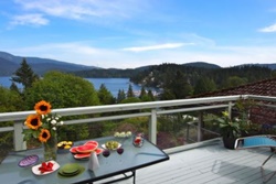 panoramic mountain views from a balcony with outdoor furniture and table set with sunflowers and appetizers, pet friendly by owner vacation rentals in vancouver